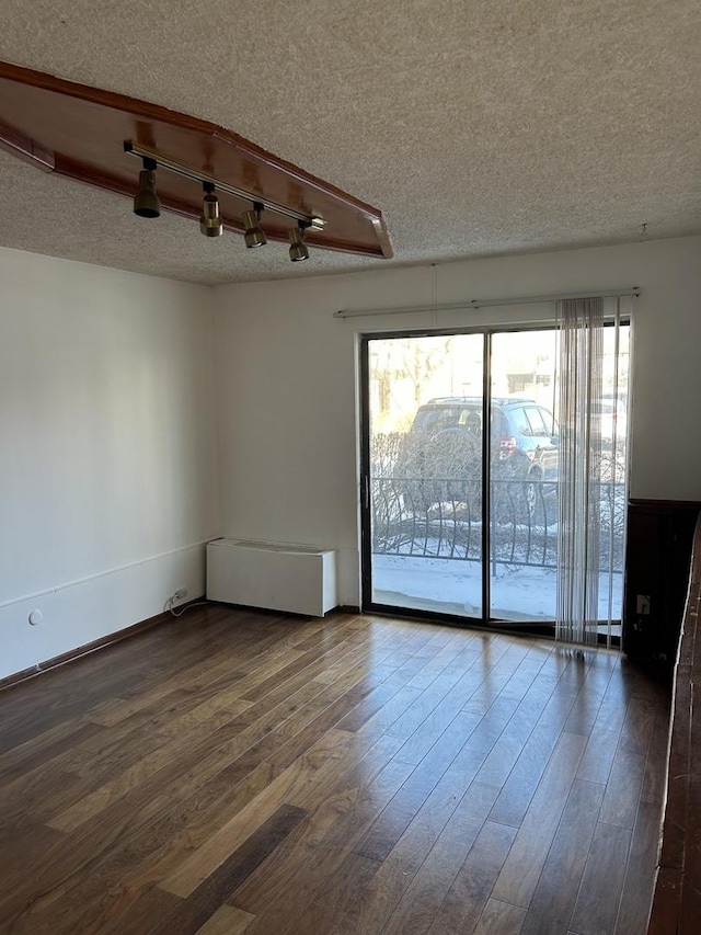 spare room featuring a textured ceiling and wood finished floors