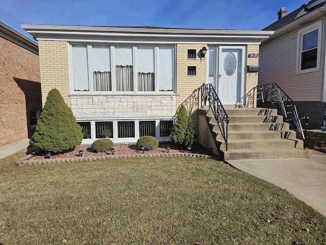 view of front of house featuring brick siding and a front lawn