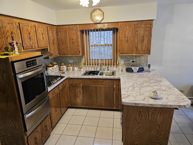 kitchen featuring light tile patterned floors, appliances with stainless steel finishes, a peninsula, and light countertops