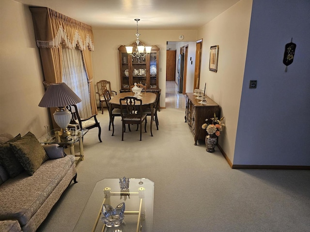 dining space with light colored carpet, baseboards, and an inviting chandelier