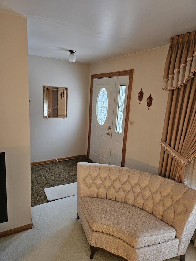 foyer featuring baseboards and carpet floors