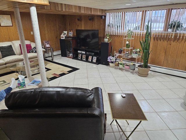 tiled living room featuring wood walls and a baseboard radiator