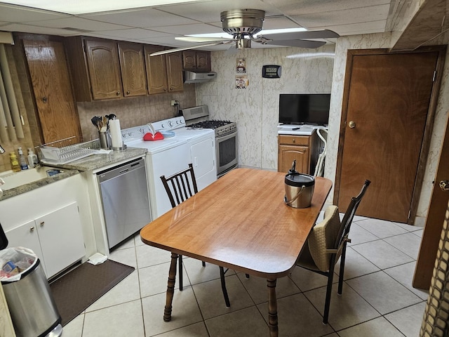 kitchen with ceiling fan, light countertops, light tile patterned floors, stainless steel appliances, and a paneled ceiling