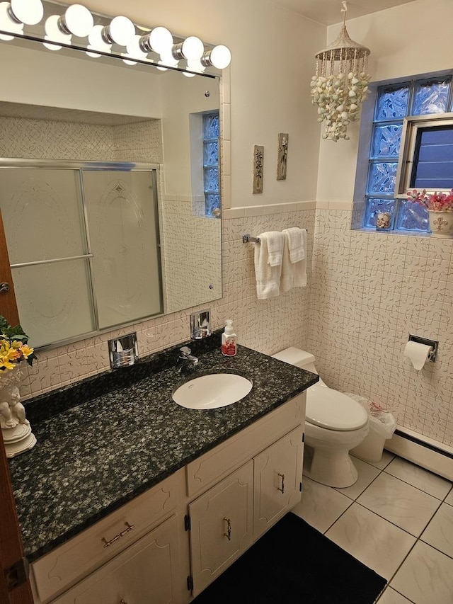 full bathroom with tile patterned flooring, a shower stall, vanity, baseboard heating, and tile walls