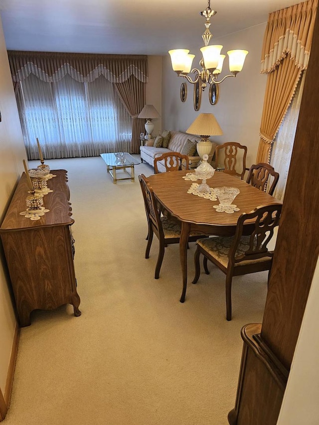 dining space featuring an inviting chandelier and light carpet