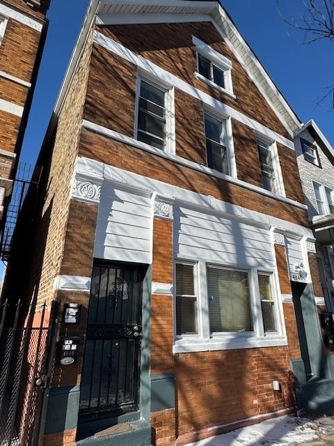 view of front of property with brick siding and fence