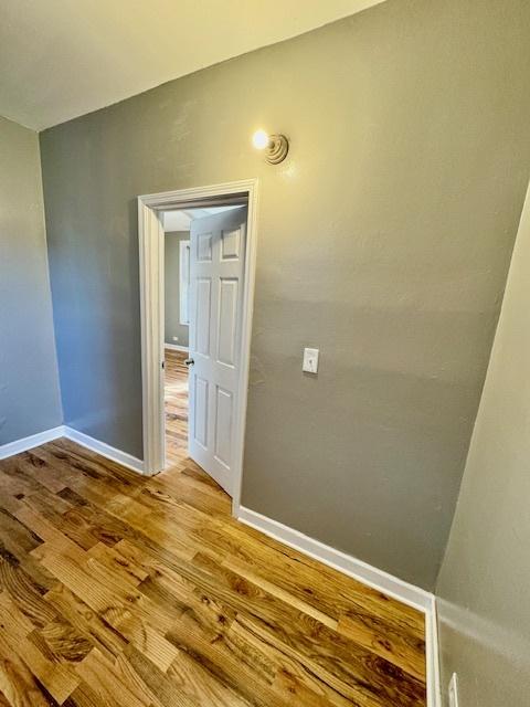 unfurnished room with wood finished floors and baseboards