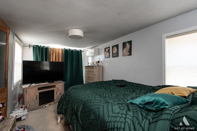 bedroom featuring an AC wall unit and light colored carpet