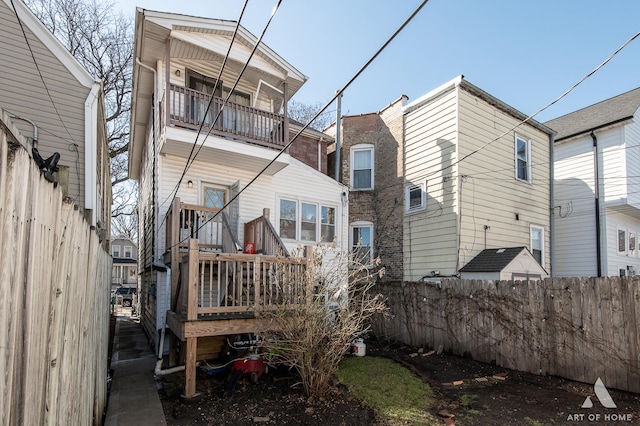 back of house with a balcony and fence