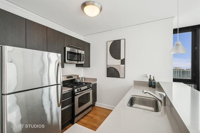 225 N Columbus Dr Unit 5610, Chicago, IL 60601 - kitchen with appliances with stainless steel finishes, a sink, light wood-style flooring, light countertops, and pendant lighting