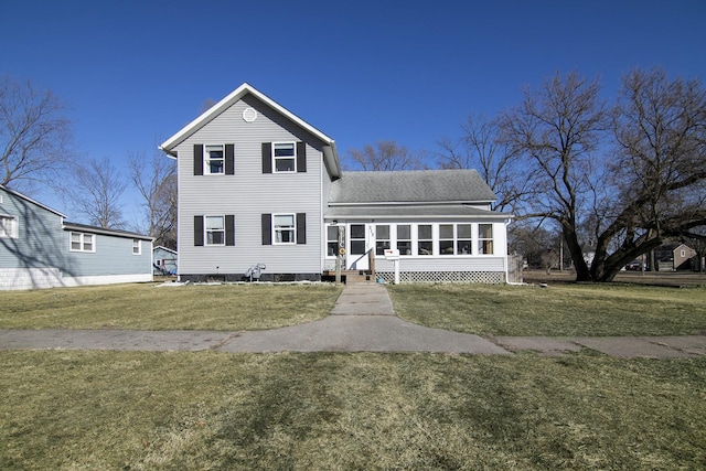 traditional home with a front lawn, a shingled roof, and a sunroom