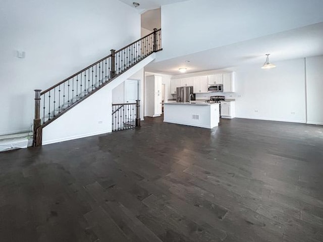 1571 Glenbrooke Ln, New Lenox, IL 60451 - unfurnished living room featuring baseboards, a high ceiling, stairway, and dark wood finished floors