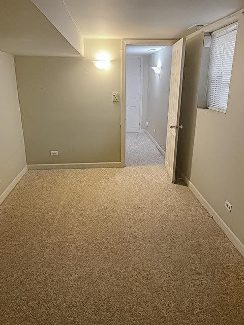 unfurnished room featuring light colored carpet and baseboards