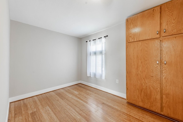 unfurnished bedroom with light wood finished floors and baseboards