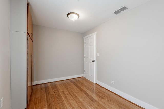 unfurnished bedroom featuring baseboards, visible vents, and light wood finished floors