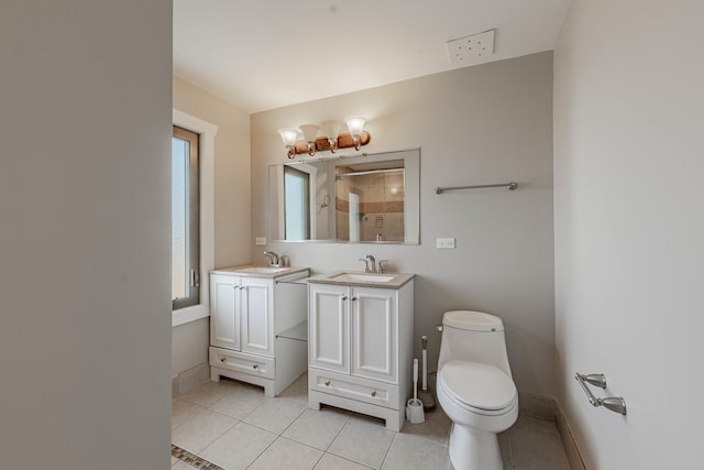 bathroom with two vanities, tile patterned flooring, a sink, and baseboards