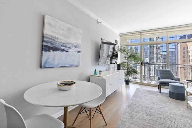 dining area with ornamental molding, light wood-type flooring, and floor to ceiling windows