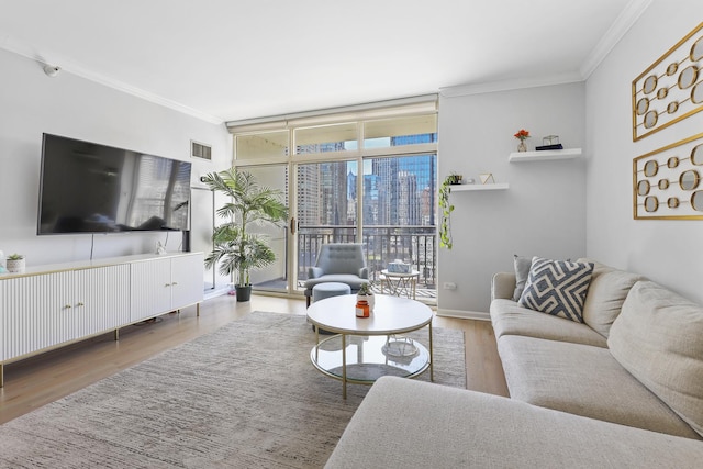 living room with a wall of windows, visible vents, ornamental molding, and wood finished floors