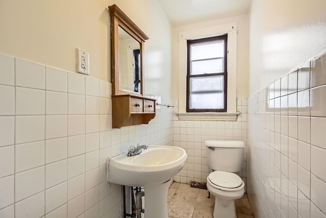 bathroom with tile patterned flooring, a wainscoted wall, tile walls, and toilet