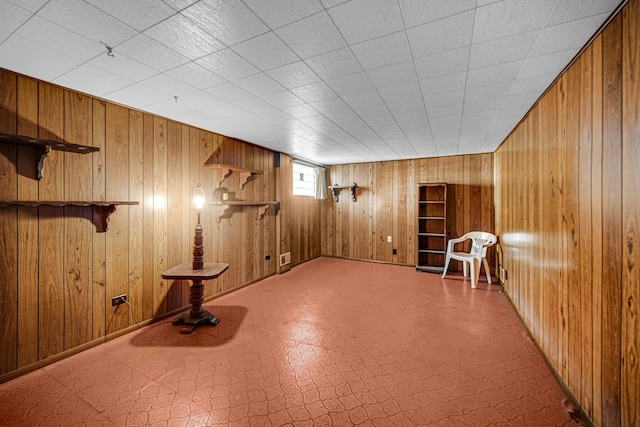 below grade area featuring wood walls and tile patterned floors