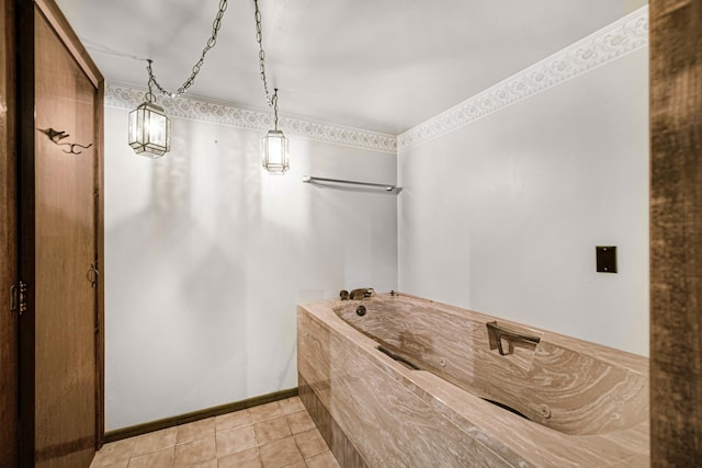 bathroom with baseboards, a tub with jets, and tile patterned floors