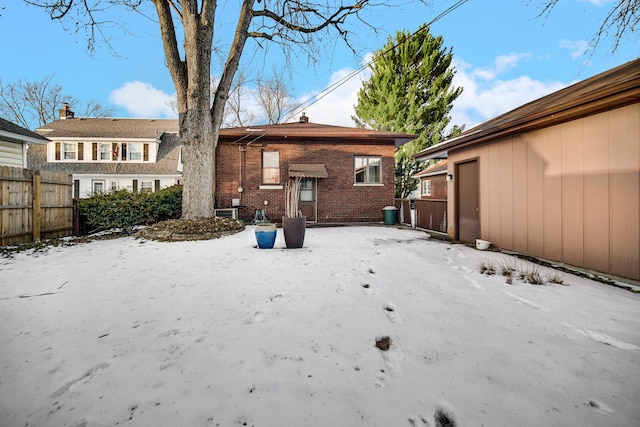 exterior space featuring brick siding and fence