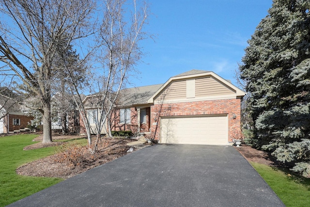 ranch-style home with driveway, a garage, a front lawn, and brick siding