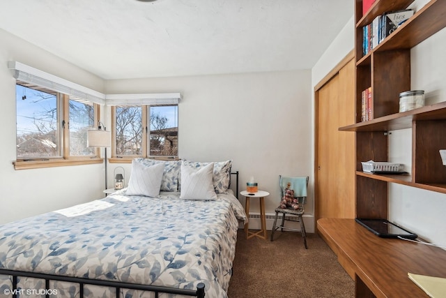 bedroom with a closet, dark carpet, and a baseboard radiator