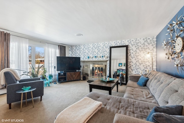 living room featuring wallpapered walls, visible vents, carpet flooring, and a glass covered fireplace