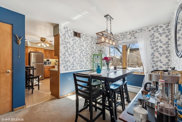 dining space with light carpet, wallpapered walls, ceiling fan, and visible vents