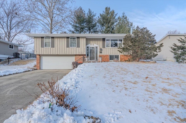 split foyer home featuring concrete driveway, brick siding, and an attached garage