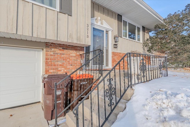 snow covered property entrance with brick siding