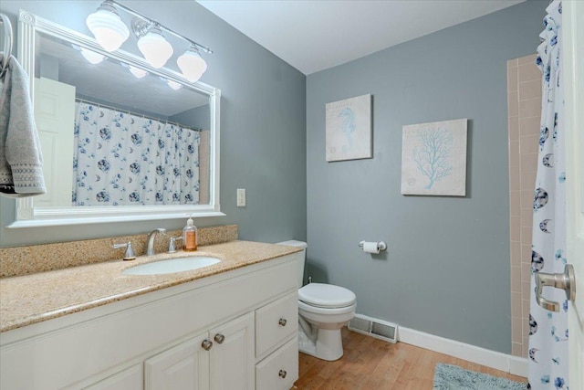 full bathroom featuring toilet, wood finished floors, vanity, visible vents, and baseboards