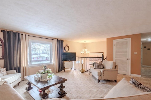 living area with baseboards, a notable chandelier, and light colored carpet