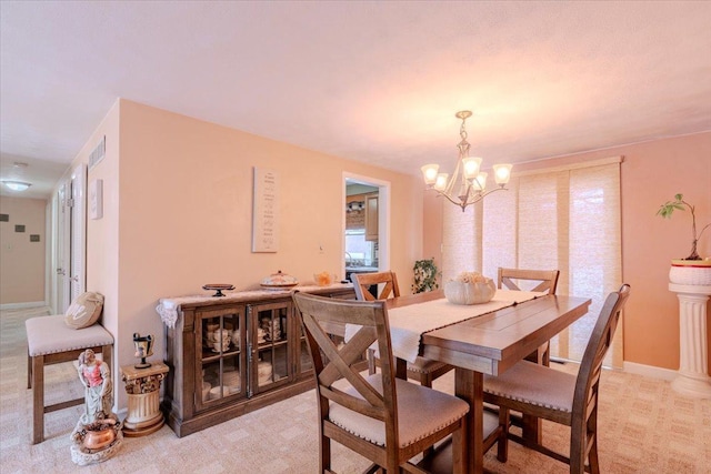 dining area with baseboards, a chandelier, and light colored carpet