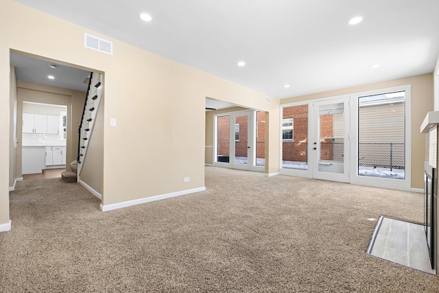 empty room featuring visible vents, baseboards, carpet, stairs, and recessed lighting