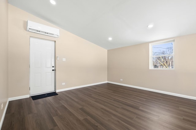 unfurnished room with lofted ceiling, recessed lighting, baseboards, a wall mounted AC, and dark wood finished floors