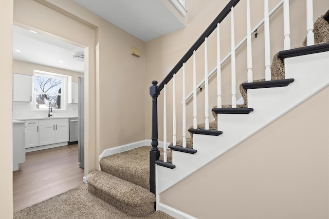 staircase featuring baseboards and wood finished floors