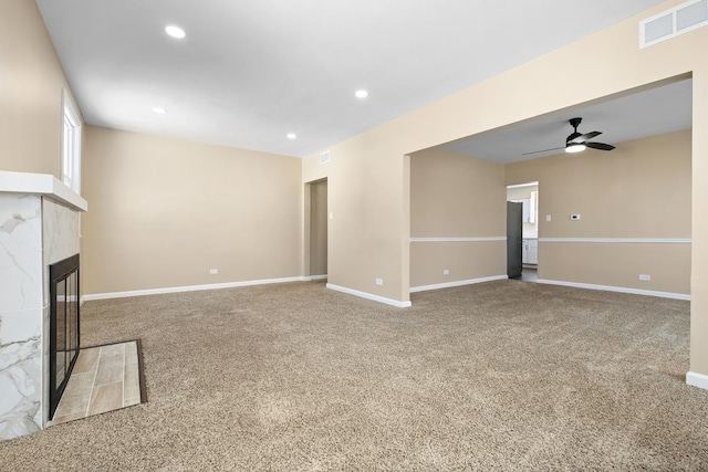 unfurnished living room with carpet, recessed lighting, visible vents, a tiled fireplace, and baseboards