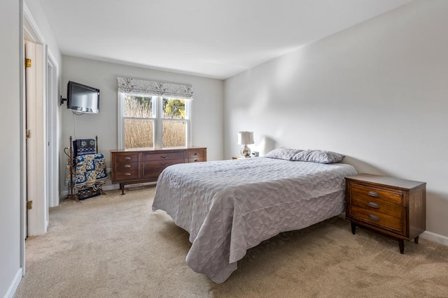 bedroom featuring light colored carpet and baseboards