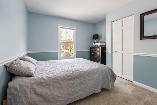 carpeted bedroom with baseboards and a closet