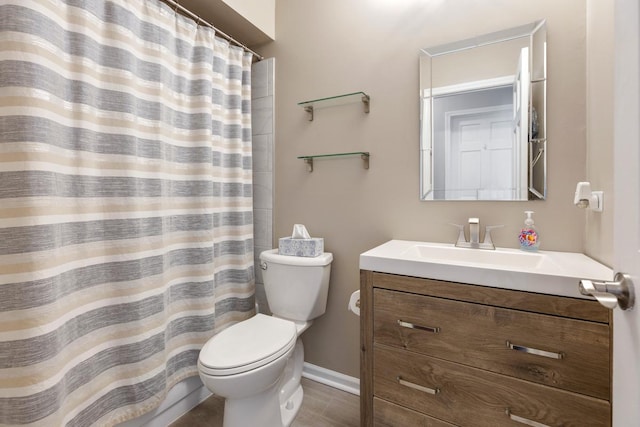 bathroom featuring toilet, baseboards, a shower with shower curtain, and vanity