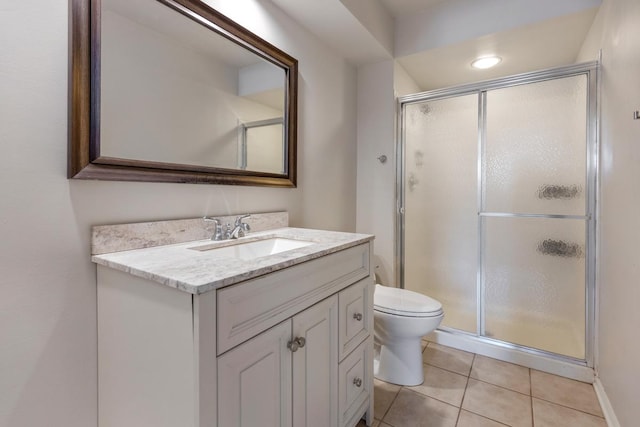 full bathroom with a shower stall, vanity, toilet, and tile patterned floors