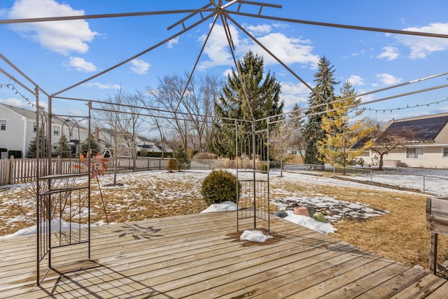 snow covered deck with a residential view and fence