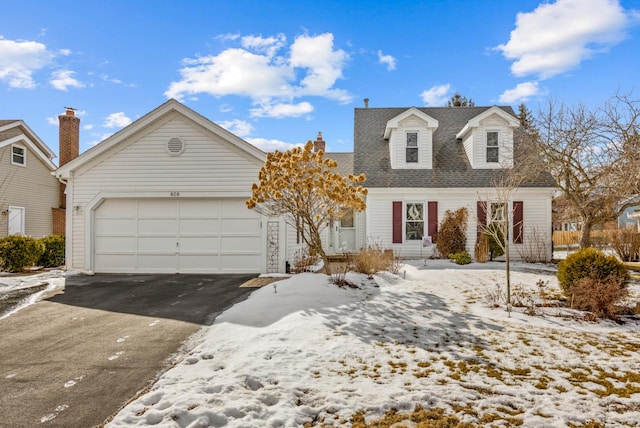 cape cod-style house with an attached garage, a shingled roof, and aphalt driveway