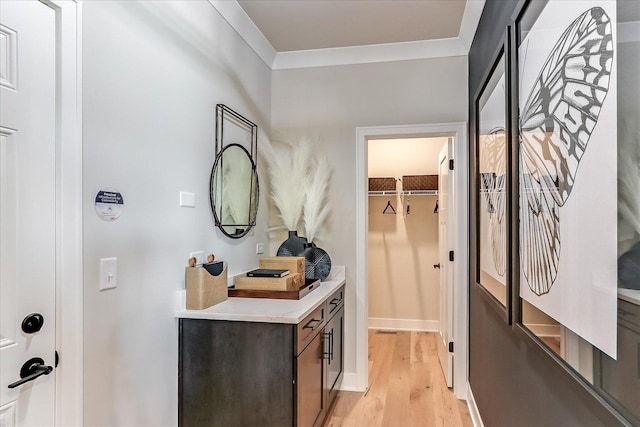 doorway featuring light wood-type flooring and crown molding