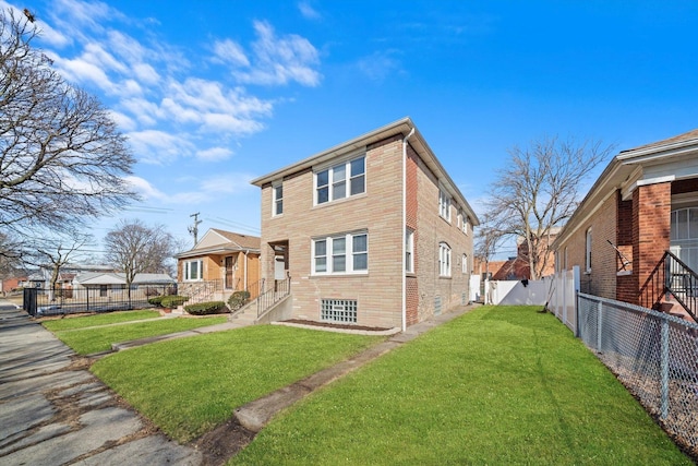 view of front of house featuring brick siding, a front yard, and a fenced backyard