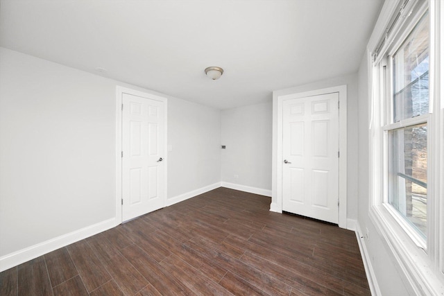 spare room with dark wood-style flooring and baseboards