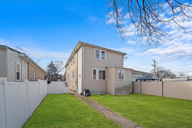 back of house with a lawn and a fenced backyard