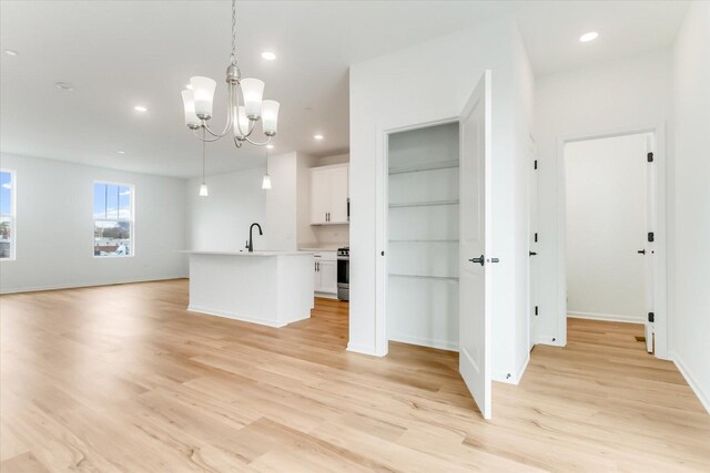 1121 Girard Ave, Des Plaines, IL 60018 - kitchen with open floor plan, light wood-style floors, white cabinets, a chandelier, and light countertops